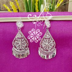 Beautiful and stunning handmade Mexican Filigree Earrings. Each piece is meticulously created out of copper wire and spun into a beautiful design. To give it the final touch artisans dipped into silver plate for it's elegant silver color. This accessory is an important part of the traditional Tehuana outfit from Oaxaca, Mexico. Look elegant while wearing Mexico's culture with this one of a kind earrings! Approximate length: 3.5-4 in Need more than one? Ask us about our combined flat rate shipmen Silver Teardrop Flower Earrings For Pierced Ears, Silver Teardrop Flower Earrings, Bohemian Silver Flower Earrings For Wedding, Silver Bohemian Flower Earrings For Wedding, White Bohemian Filigree Earrings, Silver Teardrop Chandelier Earrings For Festivals, White Intricate Design Dangle Earrings, Festival Silver Teardrop Chandelier Earrings, Ornate White Dangle Earrings