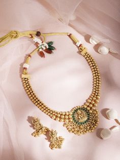 This jewellery set consists of a necklace and a pair of earringsThe gold-plated necklace has a green/red stone-studded Lakshmi motif, secured with a draw-string closureA pair of matching drop earrings, each secured with a post and back closure. Size & Fit Necklace: 21 cmEarrings: 2.5 cm Material & Care Material: BrassPlating: Gold-platedStone Type: Artificial stones Care Instruction Wipe your jewellery with a soft cloth after every useAlways store your jewellery in a flat box to avoid accidental scratchesKeep sprays and perfumes away from your jewelleryDo not soak your jewellery in waterClean your jewellery using a soft brush, dipped in jewellery cleaning solution only Dispatch within 7 days Gold Plated Kundan Necklace For Festivals Temple Jewelry, Gold Plated Round Temple Necklace For Festive Occasions, Gold Plated Meenakari Jewelry For Puja, Festive Gold Plated Round Temple Necklace, Gold Plated Kundan Necklace For Temple Jewelry Gift, Temple Jewelry Style Gold Plated Kundan Necklace As Gift, Gold Plated Temple Jewelry Sets, Gold Plated Temple Jewelry For Diwali, Diwali Temple Jewelry In Gold Plated