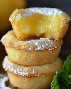 a stack of lemon shortbreads with powdered sugar on top and mint sprigs