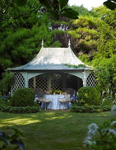 a white gazebo sitting on top of a lush green field