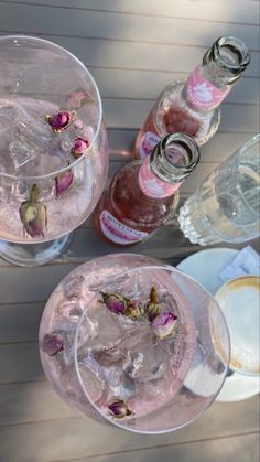 two glasses filled with ice and pink flowers