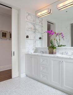 a bathroom with two sinks and a large mirror on the wall next to each other