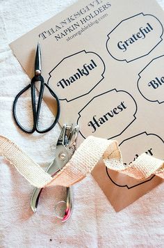 a pair of scissors sitting on top of a piece of paper next to a ribbon