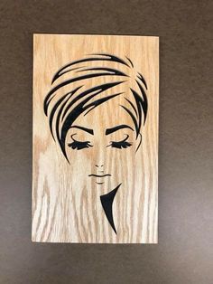 a wooden plaque with an image of a woman's face in black and white