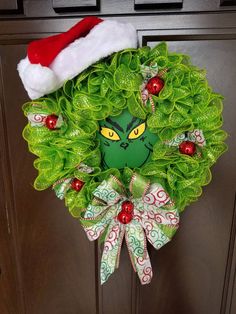 a christmas wreath with an elf's face on it hanging from the front door