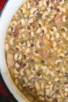 black - eyed peas with bacon in a white bowl on a red tablecloth and text overlay reads southern style black - eyed peas