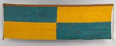 a yellow and blue rug hanging on a wall