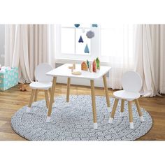 a child's table and two chairs in a room with wooden floors, white walls and curtains