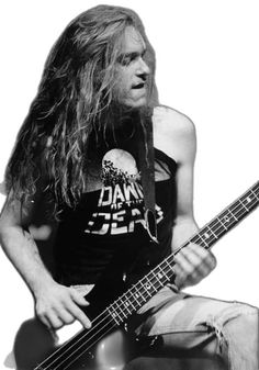 a man with long hair playing a bass guitar