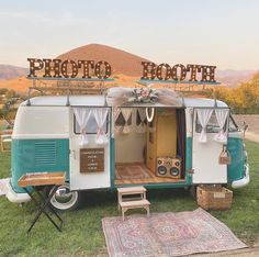 an old camper is parked in the grass near a sign that says photo booth