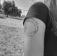 a woman's arm with a circle tattoo on the back of her left arm