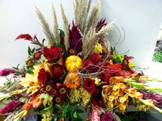 an arrangement of flowers and foliage on a table