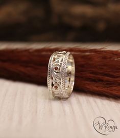 a close up of a ring on top of a piece of wood with hair in the background