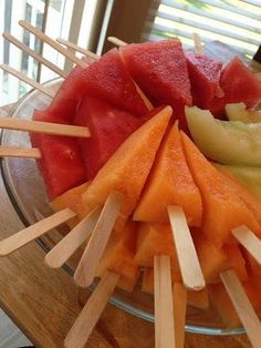 watermelon, melon and pineapple on skewers in a glass bowl