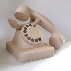 an old fashioned phone sitting on top of a white surface with holes in the middle