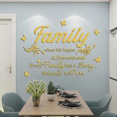 a dining room table with blue chairs and a wall decal that says, family where life begins