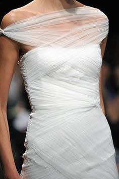 a woman in a white dress on the runway