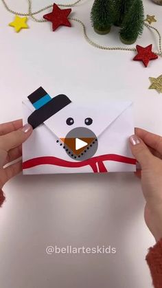 someone is holding an envelope with a snowman on it