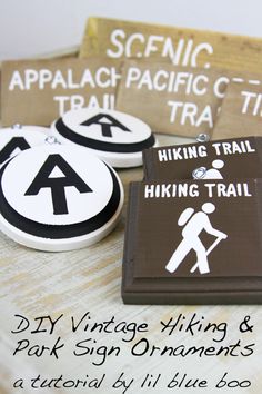 some badges and magnets on a table with writing about hiking trail signs in black and white