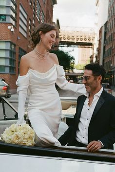 the bride and groom are sitting in the back of an old pickup truck on their wedding day