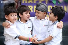 three young boys standing next to each other in front of a happy birthday sign