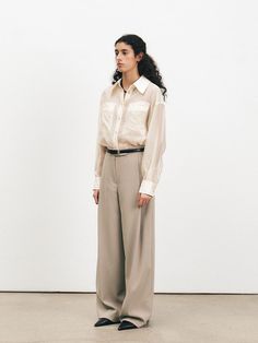 These One Tuck Semi Wide Trousers offer a modern interpretation of classic tailoring. The single tuck detail at the waist creates a subtle fullness, leading down to a semi-wide leg that provides a contemporary silhouette. These trousers are a versatile garment, easily styled for both formal and casual occasions. - The One Tuck Semi Wide Trousers feature a mid-rise waist, flattering for various body types.- Constructed from a premium fabric, they drape elegantly while offering long-lasting wear.- The semi-wide leg cut strikes a balance between trend-forward styling and timeless appeal.- Equipped with side pockets and a clean zip fly closure, these trousers are as practical as they are fashionable. Timeless Wide Leg Pants For Workwear In Spring, Elegant Neutral Bottoms With Belt Loops, Classic Relaxed Fit Wide Leg Pants For Daywear, Classic Wide Leg Pants With Pockets For Daywear, Elegant Neutral Pants With Welt Pockets, Elegant Neutral Pants With Belt Loops, Classic Wide Leg Pants For Spring, Classic Wide Leg Pants For Daywear, Classic Wide Leg Pants For Spring Daywear