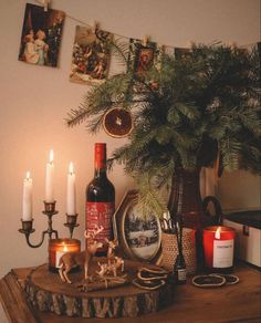 a table topped with candles and pictures next to a christmas tree