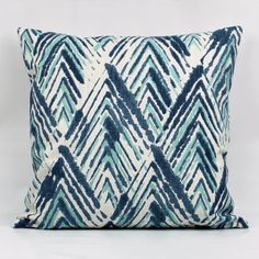 a blue and white pillow on a white background