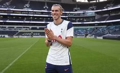 a man standing on top of a soccer field holding his hands in front of him