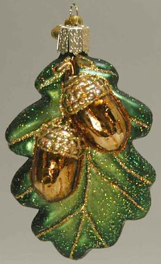 a green and gold christmas ornament hanging from a tree with glittery leaves