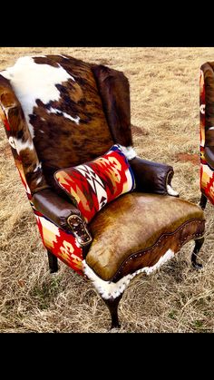 a cow hide chair and footstool in the middle of a field with dry grass