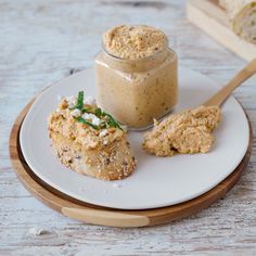 a white plate topped with food next to a jar of peanut butter