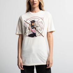 a woman standing in front of a white wall wearing a t - shirt with an anime character on it