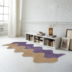 a living room with white brick walls and purple rugs on the floor next to a book shelf