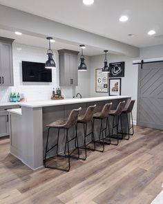 a kitchen with gray cabinets and bar stools