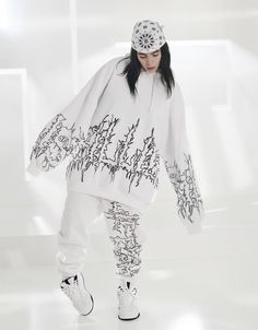 a woman in white is standing on a skateboard with graffiti written all over her