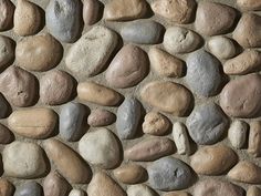 a stone wall with several different colored rocks on it