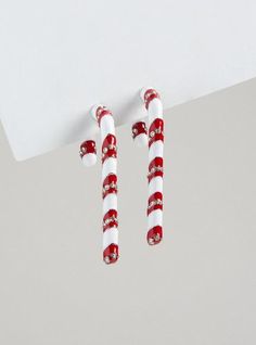 red and white candy canes hanging from the ceiling in front of a gray wall