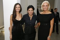 three women standing next to each other in formal wear