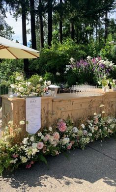 an outdoor bar with flowers and drinks on it