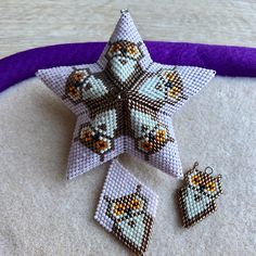 a cross stitch star ornament and two matching earrings