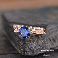 a tan gold ring with an oval blue sapphire surrounded by white diamonds on a rock