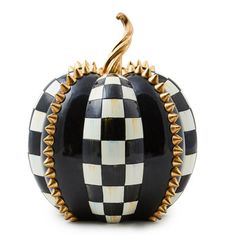 a black and white checkered pumpkin with gold spikes on it's sides, sitting in front of a white background