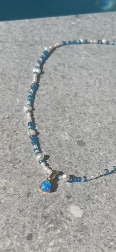 Beautiful blue seed bead necklace with real freshwater pearls, 24 karat gold plated details and a beautiful opal imitation charm. Necklace is approximately 42 cm long + 3 cm extend chain. Beaded measure between 3-5 mm in size. Cheap Blue Beaded Necklace For Gift, Blue Pearl Necklace With Round Beads Pendant, Blue Beaded Necklaces With Pearl Pendant, Blue Beaded Necklace With Pearl Pendant, Blue Beaded Necklace With Pearl Drop For Gift, Handmade Blue Pearl Pendant Necklace, Blue Pendant Necklace With Pearl Drop, Handmade Blue Pendant Pearl Necklace, Blue Pearl Beaded Necklaces With Pearl Charm