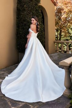 a woman in a white wedding dress standing outside