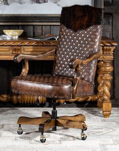 an old fashioned desk chair with leather upholstered back and arm rests on casteors