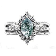 a white gold ring with an aqua green stone and diamond accents on the band, set against a white background