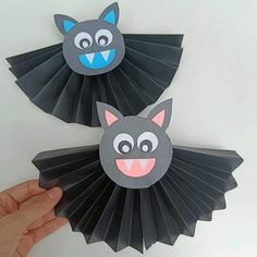 two paper bats that have faces on them