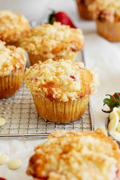 muffins cooling on a wire rack with strawberries and other dessert items nearby