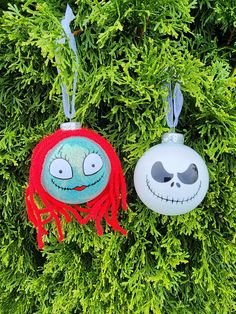 two ornaments hanging from a tree in the shape of jack skellingy and jack o lantern